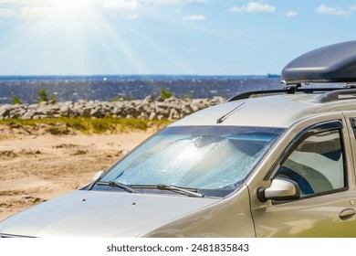 Protective reflective surface under the windshield of the passenger scar parked on a hot day, heated by the sun's rays inside on sea ocean coast beach embankment