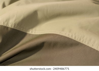 protective work clothes in beige and brown colors. Factory stitches on thick fabric. Close-up texture