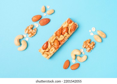 Protein Bar And Nuts On Blue Background Close Up Top View.