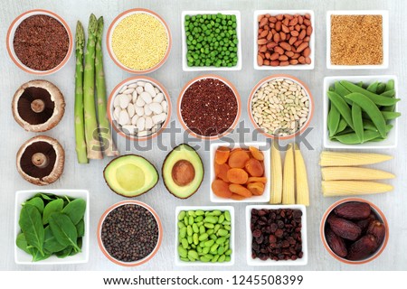 Protein plant health food selection for a healthy diet with grain, legumes, dried fruit, seeds, nuts and vegetables on rustic wood background. Foods high in fibre, antioxidants, vitamins and minerals.