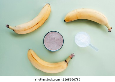 Protein Powder And Cocktail In A Glass And Banana On Light Green Background. Healthy Food. Top View, Flat Lay.