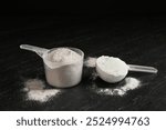 Protein powders in scoops on dark textured table