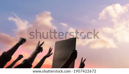 Protest, Mob, Expression and Strike Concept.  Silhouette of People Raise Up Hands into the Sky. the Leader Holding a Corrugated Paper.