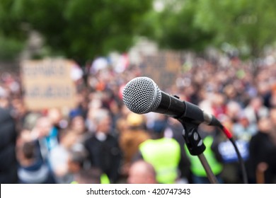 Protest. Public Demonstration. Microphone In Focus Against Blurred Audience.