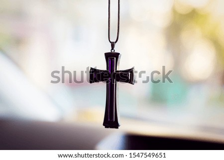 Protestant Christian cross on a string on a blurred background