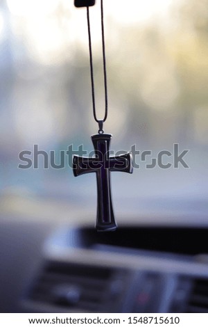 Protestant Christian cross on a string on a blurred background