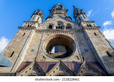 A Protestant Church Under Bluesky And White Could, The Kaiser Wilhelm Memorial (Kaiser-Wilhelm-Gedächtniskirche) Located On The Kurfürstendamm In The Centre Of The Breitscheidplatz, Berlin, Germany.