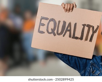 A protester holds up a cardboard sign reading "EQUALITY," symbolizing the fight for equal rights, justice, and social change. - Powered by Shutterstock