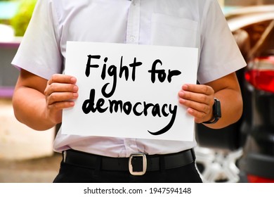 Protester holds wordcard 'Fight for democracy‘, concept for calling all people to be protesters and fight for democracy from revolutions, coups, and restrictions on freedom from the people.