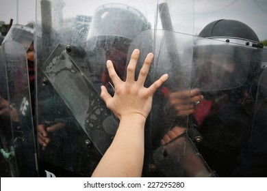 Protester Pushes Police Riot Shields at a Political Rally - Shutterstock ID 227295280