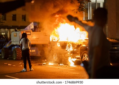 A protester was walking around a burning car. Many protesters gathered around in front of White House in Washington DC on 5/30/2020. No justice no peace.
