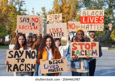 Protesters demonstrating different anti racism slogans outdoors. People holding signs with phrases - Powered by Shutterstock