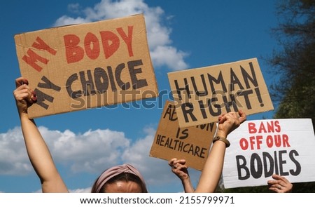 Protesters holding signs My Body My Choice, Human right, Bans Off Our Bodies, Abortion Is Healthcare. People with placards supporting abortion rights at protest rally demonstration.
