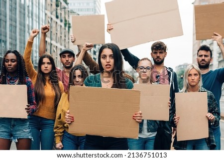 protestors strike with blank banners - crowd on street holding empty placards - multiethnic people on street showing ready to use cardboards with copy space  
