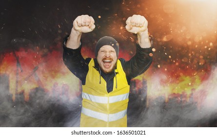Protests Yellow Vests, Struggle For Equal Rights, Electoral Movement. Man Eaised Hands In Fists and Screams against the background of a burning city
