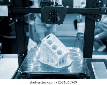 Prototype of car engine printed on 3D printer from molten white plastic on working surface 3D printer. Three-dimensional model. Additive modeling technology. Modern new printing industry. Blue color