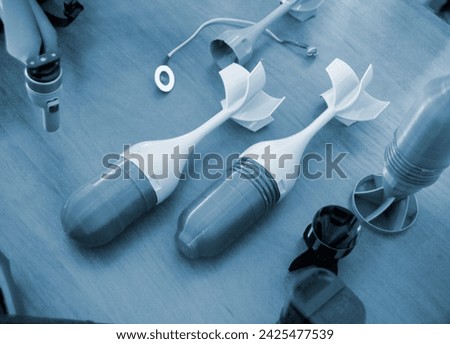 Prototype model of rocket bomb tip printed on 3D printer. Small models of tail fins, tail cone printed on 3D printer from molten plastic. Military weapons. New modern innovation printing technology