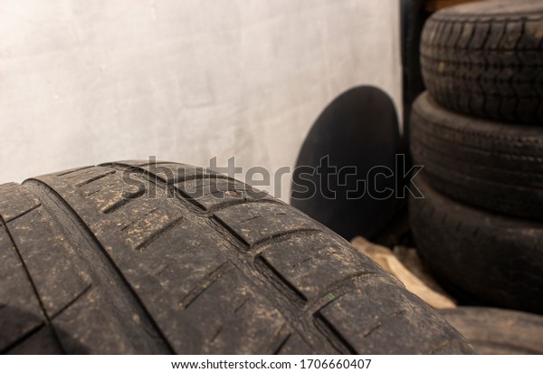 Protruding self-tapping screw from the tire of\
the wheel close-up. A punctured car wheel on a tire fitting against\
the background of other\
wheels.