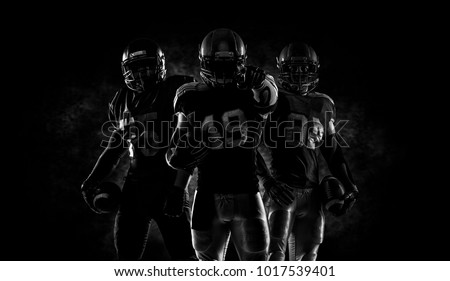 Proud american football players in dark