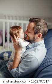 Proud Caucasian Father Talking To Newborn Baby Girl. Parent Holding Rocking Child Daughter In Hands. Authentic Lifestyle Happy Parenting Fatherhood Moment. Single Dad Family Home Life.