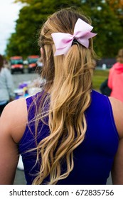 Proud Cheerleader With Blond Hair And A Pink Bow