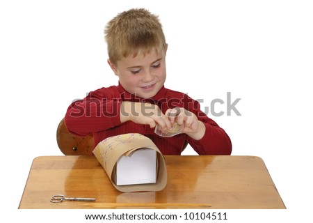 Proud child wrapping a gift with paper he colored