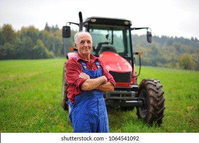 Proud Farmer Standing In Front Of His Red Tractor 