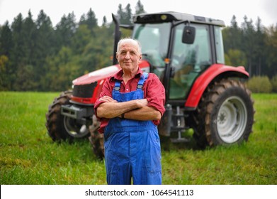 Proud Farmer Standing In Front Of His Red Tractor 