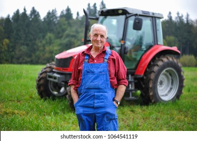 Proud Farmer Standing In Front Of His Red Tractor 