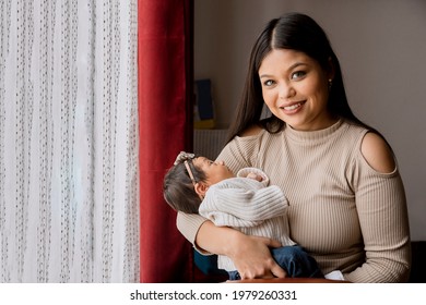 Proud Hispanic Mom Holding Her Newborn Baby - Latin Mother And Daughter At Home