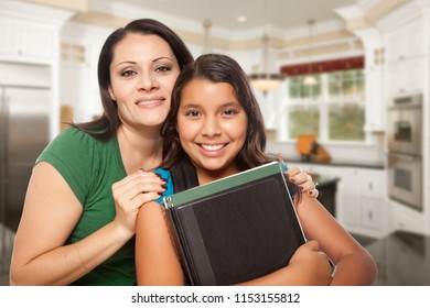 Proud Hispanic Mother And Daughter In Kitchen At Home Ready For School.