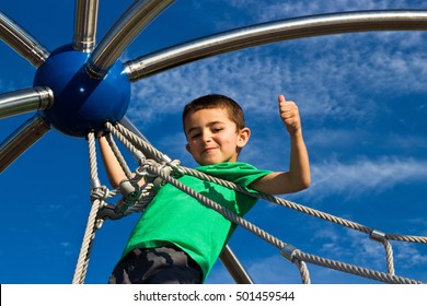 Proud little boy climbs the jungle gym at the park - Powered by Shutterstock