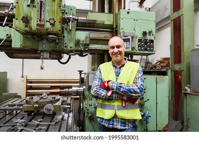 Proud Metal Worker As A Machinist In Front Of The Coordinate Drilling Machine In The Metal Factory