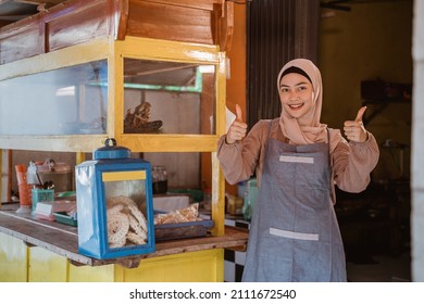 proud muslim woman with her small food stall thumb up - Shutterstock ID 2111672540