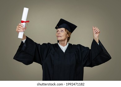 Proud Older Woman Graduate In Graduation Gown And Cap With College Diploma