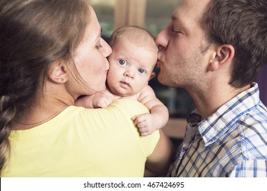 Proud Parents Holding Baby In The Bedroom