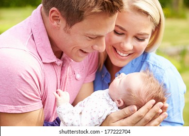 Proud Parents Holding Baby Daughter In Garden