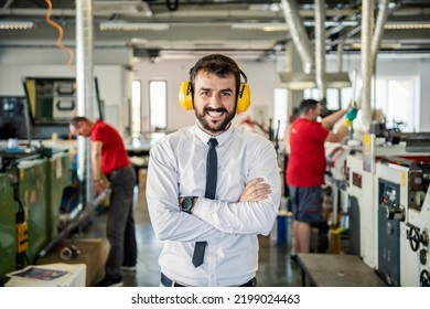 A Proud Printing Shop Manager With Antiphons Smiling At The Camera.