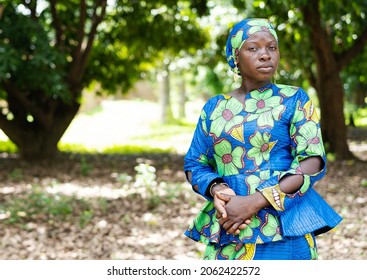 Proud young African woman in an elegant blue and green dress and matching headgear looking grimly at the camera - Shutterstock ID 2062422572