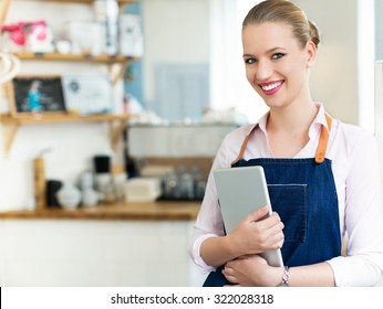 Proud young female cafe owner - Shutterstock ID 322028318