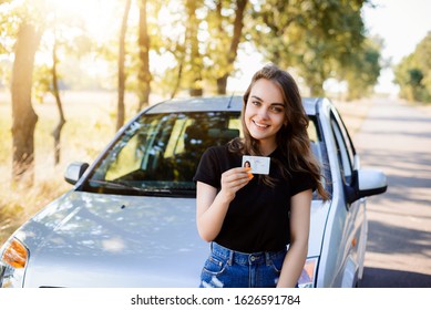 Proud young girl with car licence just after finishing driving school and getting drivers license