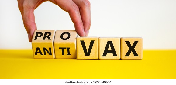 Pro-vax or anti-vax symbol. Doctor turns a cube, changes words 'anti-vax' to 'pro-vax'. Beautiful yellow table, white background. Copy space. Business, medical covid-19 pro-vax or anti-vax concept. - Shutterstock ID 1910540626