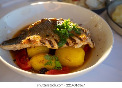 Provence Cuisine, Grilled Filet Of Seabass White Fish Served With Potatoes, Tomatoes And 
Bouillabaisse Fish Jus In French Restaurant