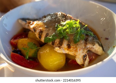 Provence Cuisine, Grilled Filet Of Seabass White Fish Served With Potatoes, Tomatoes And 
Bouillabaisse Fish Jus In French Restaurant