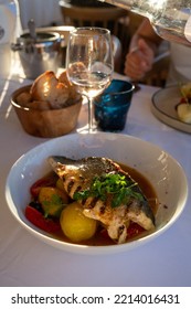 Provence Cuisine, Grilled Filet Of Seabass White Fish Served With Potatoes, Tomatoes And 
Bouillabaisse Fish Jus In French Restaurant