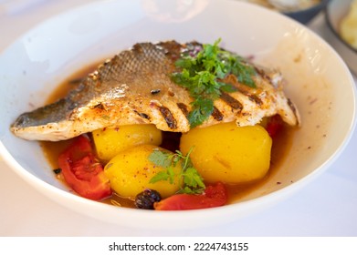 Provence Cuisine, Grilled Filet Of Seabass White Fish Served With Potatoes, Tomatoes And 
Bouillabaisse Fish Jus In French Restaurant