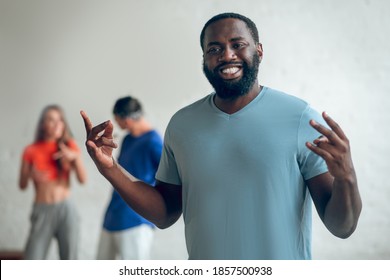 Providing a theory. A man explaining a dance routine to his colleagues - Powered by Shutterstock