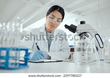 Proving my hypothesis correct. a young woman making notes in her lab.