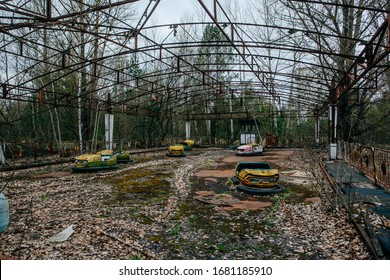 Prupyat, Chernobyl, Ukraine - April 30, 2019: Old Broken Rusty Metal Radioactive Yellow Cars, Children's Electric Cars, Abandoned Among Vegetation, The Park Of Culture And Recreation In The City Of Pr