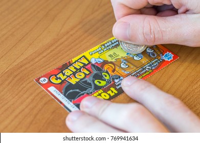 Pruszcz Gdanski, Poland - December 1, 2017: Man Scratching A Polish Lotto Lottery Ticket On Wooden Table.